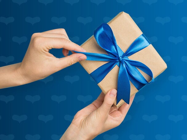 ידיים פותחות אריזת מתנה עם סרט כחול