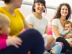 נשים יושבות וצוחקות עם תינוקותיהן על בירכיהן