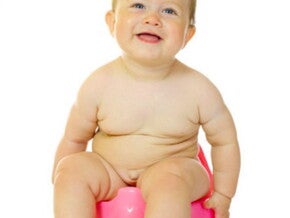 תינוק יושב על סיר ומחייך