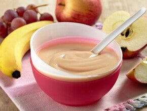 קערה עם מחית פירות על שולחן מלא בפירות