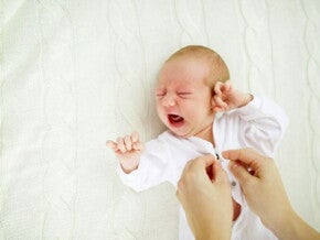 אמא מלבישה תינוק