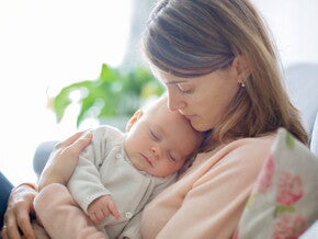 אם מחבקת את תינוקה החולה