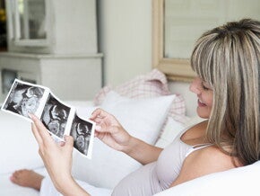 הריונית מסתכלת על תמונות אולטרסאונד