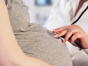 אמא בהריון וסטטוסקופ על בטנה