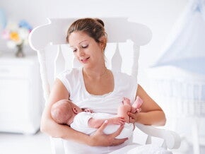 אם צעירה מניקה על כיסא