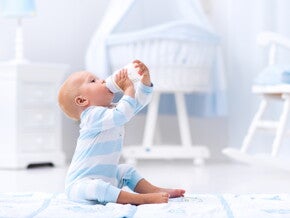 תינוק יושב ושותה מבקבוק