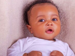 תינוק כבן חצי שנה שמח ומביט למצלמה