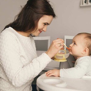 אמא מאכילה את תינוקה בדייסה