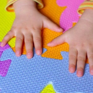 ידי תינוק על משטח סול צבעוני