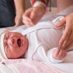 תינוק ניובורן שוכב על גבו ובוכה