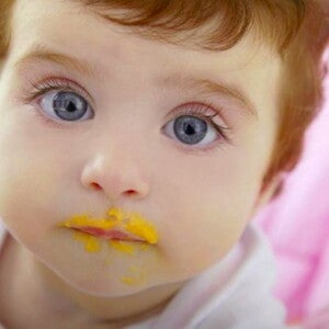 תינוק שפיו מלוכלך אחרי אכילת אוכל מחיתי כתום