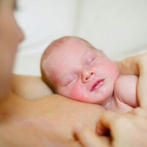 תינוק כבן חודש ישן על אימו