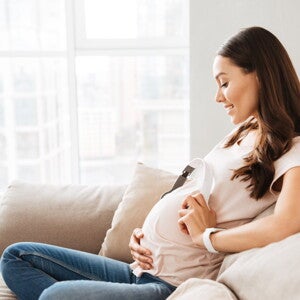 הריונית יושבת על הספה