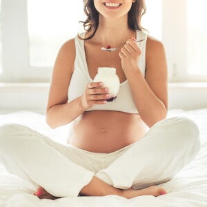 אישה בתחילת הריון אוכלת יוגורט