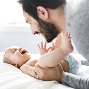 אבא מצמיד את רגליי התינוק לבטנו