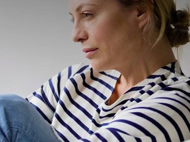 אישה אחרי לידה מביטה לפנים בעצבות