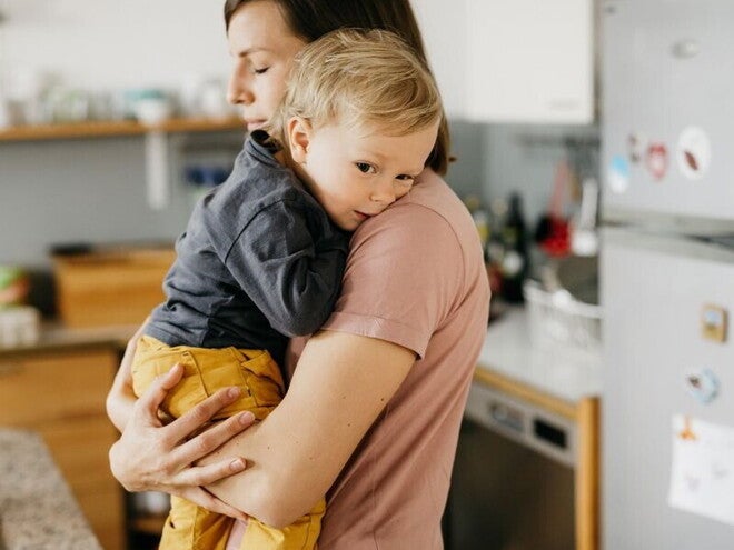 אמא מחזיקה את תינוקה על הידיים כשהם במטבח