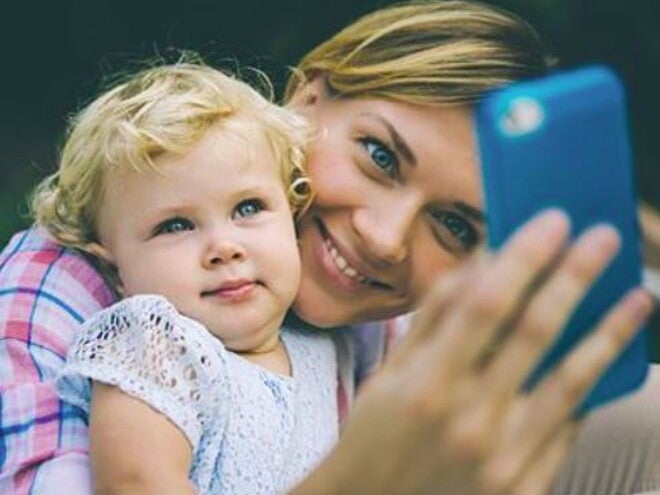 אמא וביתה מסתכלות יחד בטלפון הסלולרי