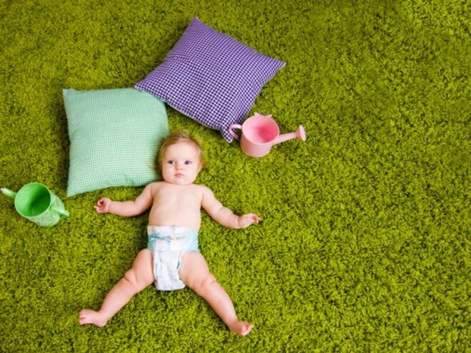 תינוק שוכב על הדשא כשלגופו חיתול