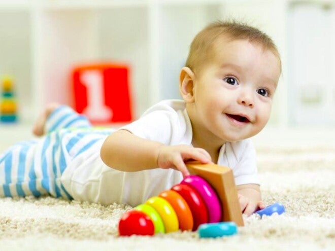 תינוק שוכב על גחונו ומשחק