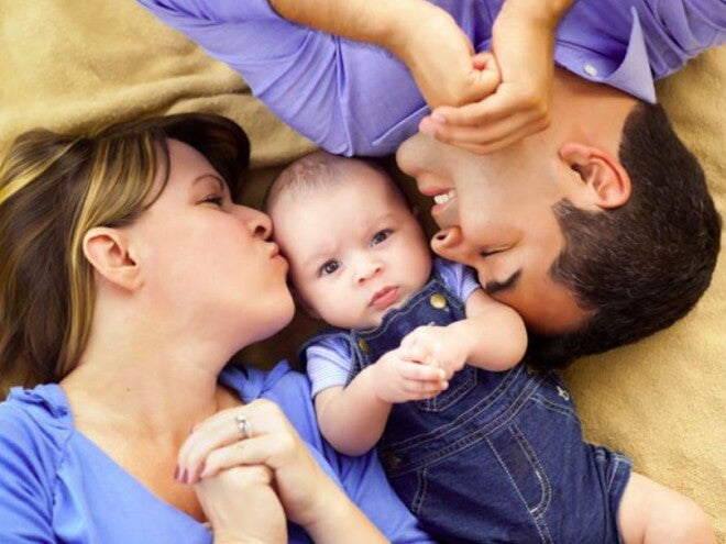 אמא ואבא מנשקים את תינוקם