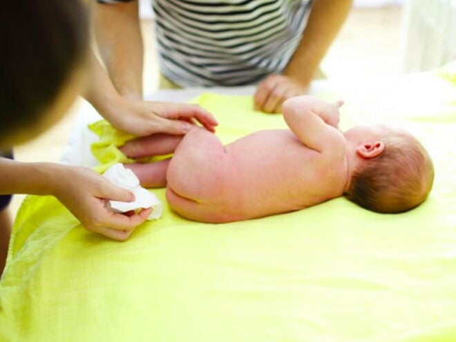 אמא ואבא מנקים את תינוקם ללא אמבטיה
