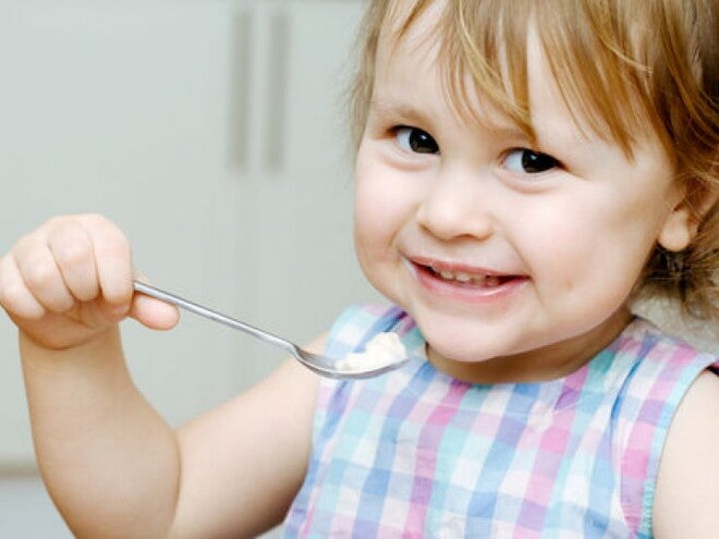 פעוטה אוכלת ומחייכת למצלמה