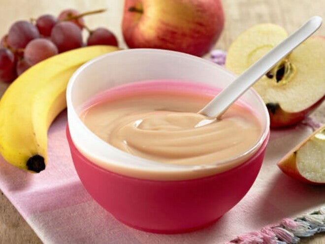 קערה עם מחית פירות על שולחן מלא בפירות