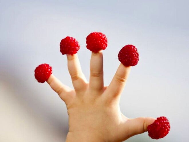 תותי עץ על אצבעותיו של פעוט