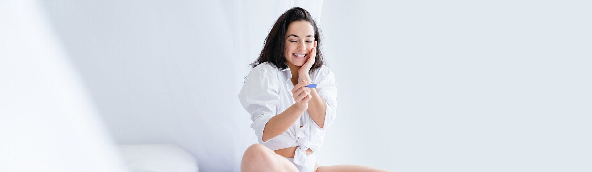 אישה שמחה כשמגלה שבדיקת ההריון שלה חיובית