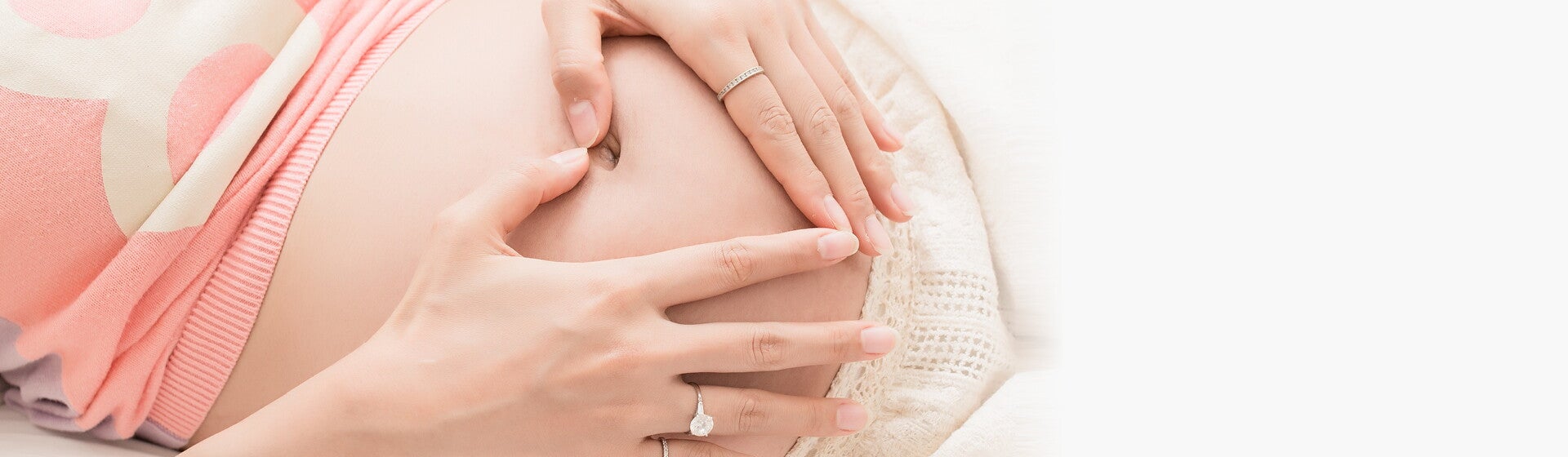 אמא מניחה באהבה את ידיה על בטנה