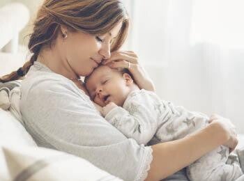 אמא מחבקת את תינוקה הרדום