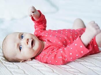 תינוקת כבת חודשיים שוכבת על גבה
